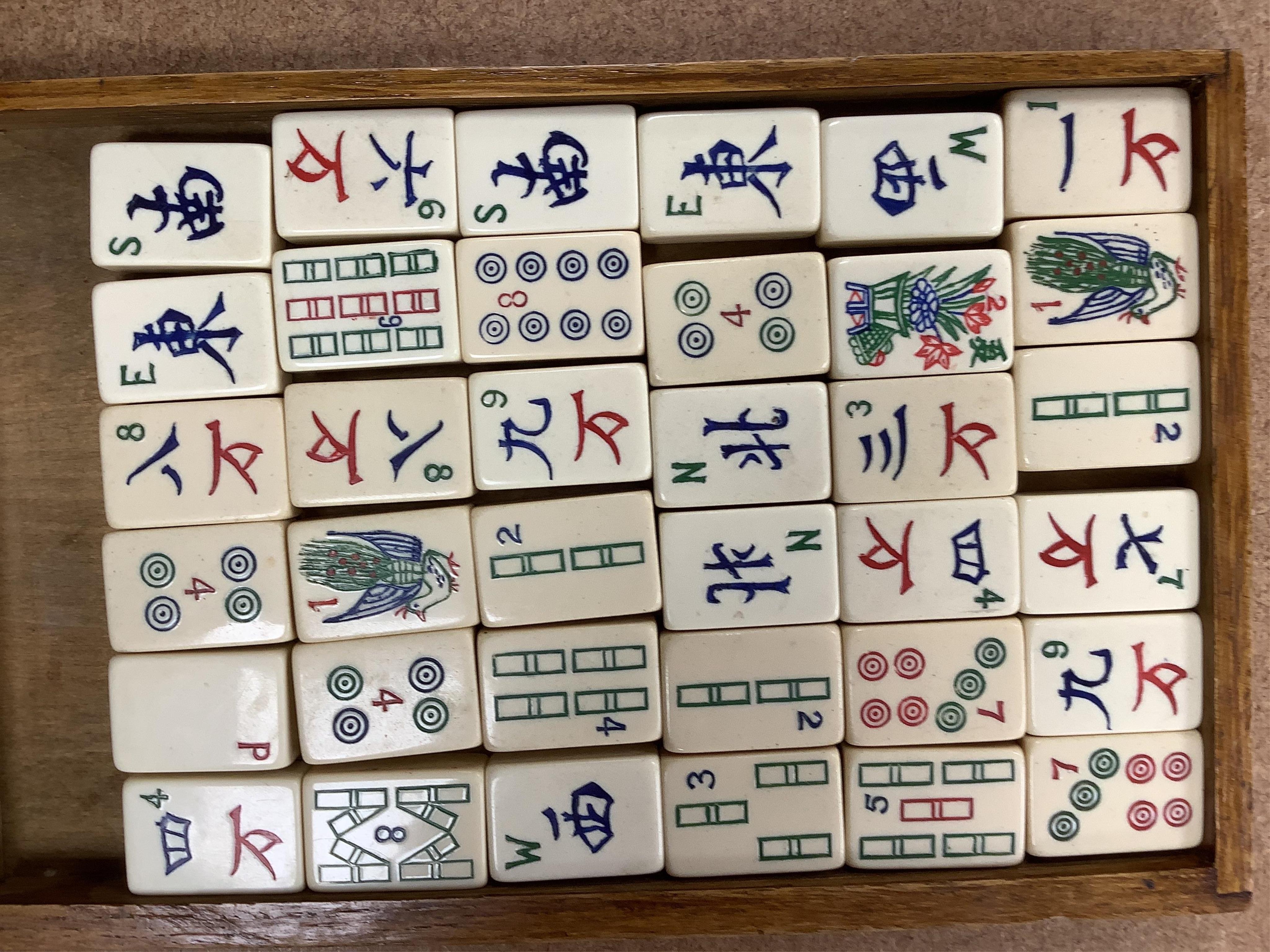 A Chinese carved small camphor box and an oak cased Mahjong set, camphor box 31cm wide, 17cm high. Condition - fair